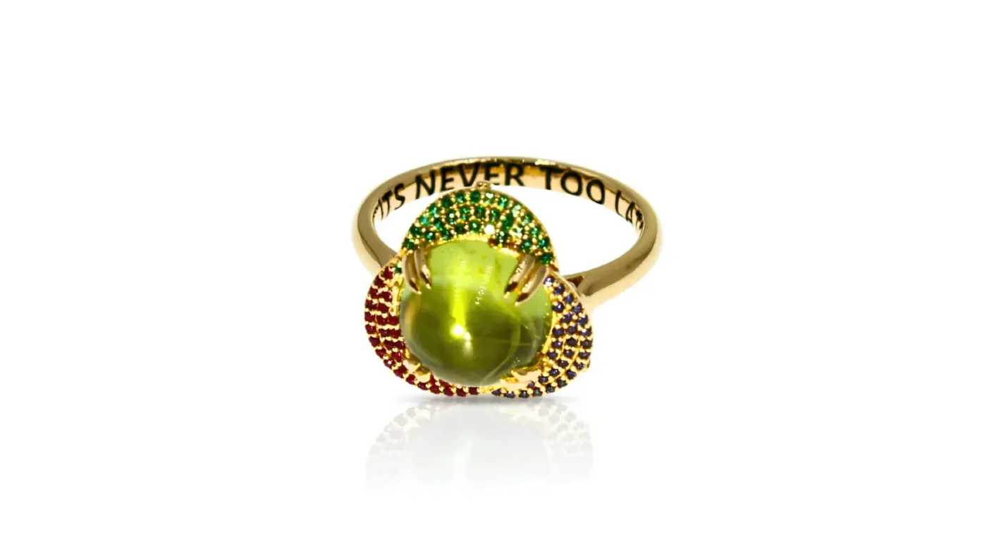 Carol Cooke’s gold It’s Never Too Late ring with green centre gemstone