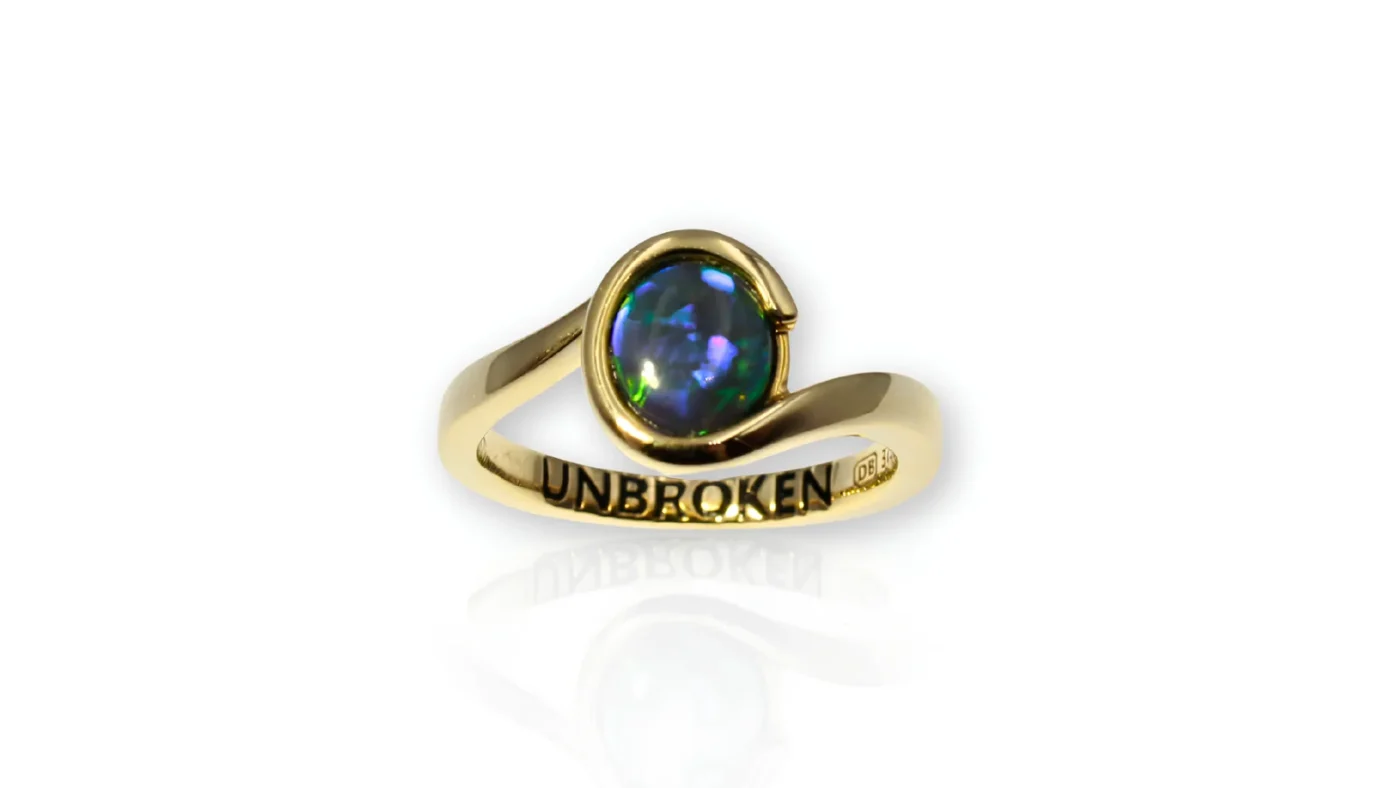 Greta Small’s custom UNBROKEN ring featuring a natural black opal in yellow gold